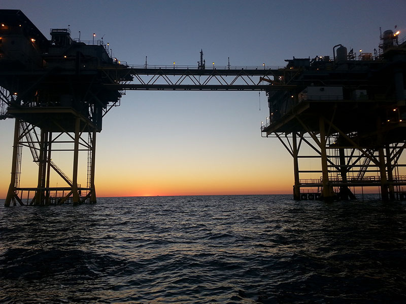 sun setting in oil rig on the ocean